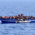 italian-navy-a-boat-filled-with-migrants-receives-aid-from-an-italian-navy-motor-boat